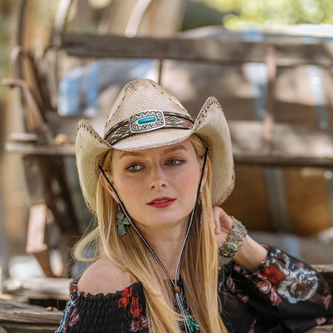 high end cowboy hat on model featuring rivets and a turquoise button